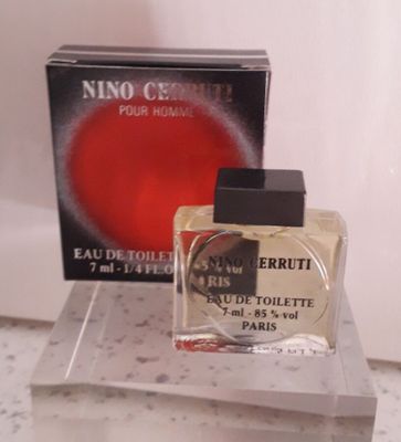un flacon de parfum posé sur un comptoir à côté d'une boîte de parfum