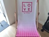 a pink and white beach chair sitting on a hard wood floor