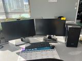 a computer desk with two monitors and a keyboard