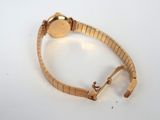 an image of a gold bracelet with a watch on top of it