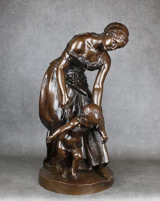 statue en bronze représentant une femme agenouillée, un enfant sur les genoux