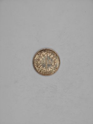 a close up of a gold coin on a white surface