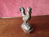 a statue of a rooster on top of a wooden table