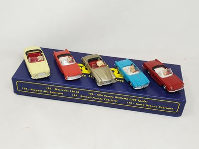 four toy cars are lined up in a row on a blue box