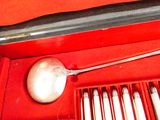 une cuillère en argent dans une boîte rouge contenant des cuillères en argent