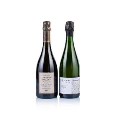 two bottles of wine sitting next to each other on a white surface