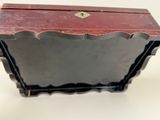 a small wooden box with a red top on a white surface