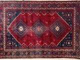 a red and blue rug with a diamond design on it