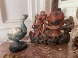 two figurines sitting on a table next to each other