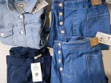 deux paires de jeans bleus et une veste en jean posées sur une étagère