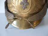 a gold helmet on a white surface with a gold emblem on it