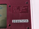 someone is drawing on the back of a red electronic device