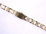 a close up of a gold bracelet on a white surface