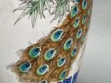 a blue and white vase with a peacock on it