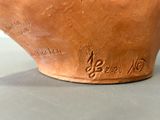 a brown vase with writing on it sitting on a table