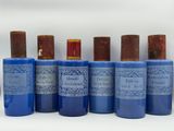 six bottles of blue perfume sitting next to each other on a white surface