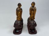 pair of antique bronze figurines of a man and a woman sitting on a lion