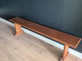 a wooden bench in the corner of a room