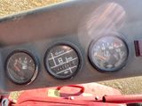 three gauges on the dashboard of a red motorcycle