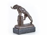 statue en bronze représentant une panthère posée sur un tonneau, sur fond blanc