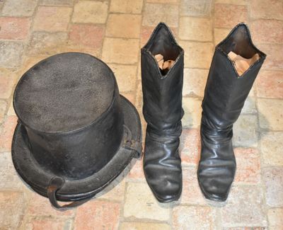 a hat and boots on the floor next to a top hat