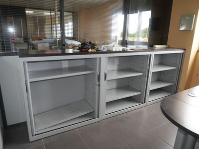 a kitchen with a counter, cabinets, and a window