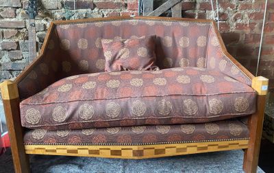 un canapé sur lequel est posé un coussin, devant un mur de briques
