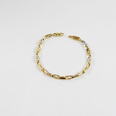 gros plan d'un bracelet en or sur fond blanc