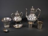 several pieces of silver are arranged on a black surface
