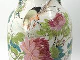 a white vase with a bird and flowers on it