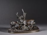 une sculpture en bronze représentant un cerf et deux antilopes posés sur un rocher