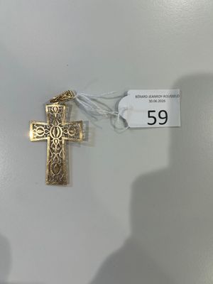 une croix en or accrochée au mur à côté d'une étiquette de prix