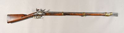 un fusil en bois accroché au mur, à côté d'un mur blanc