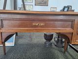 a wooden desk with a drawer underneath it and a pair of shoes on the floor