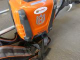 an orange and black lawn mower sitting on the ground