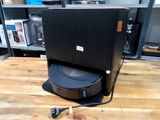 une enceinte noire posée sur une table en bois dans une pièce