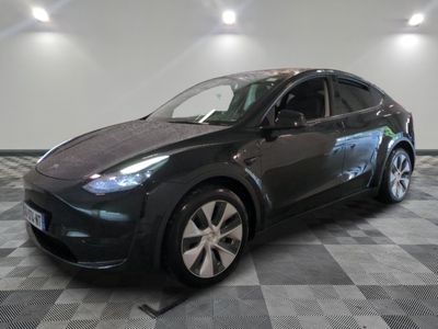 La Tesla Model Y est garée sur un sol en carrelage à damier.
