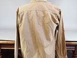 beige jacket on a mannequin stand in front of a white backdrop