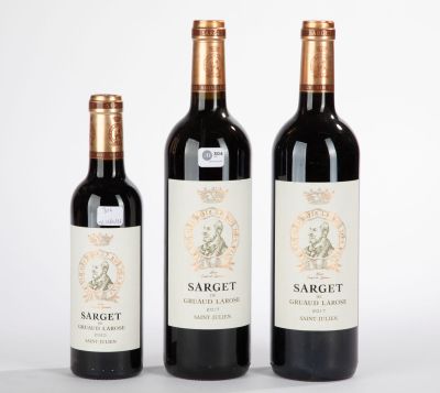 trois bouteilles de vin posées les unes à côté des autres sur une surface blanche