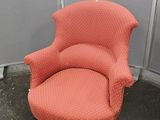 une chaise rouge qui se trouve dans le coin d'une pièce