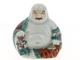 une figurine orientale représentant un Bouddha rieur assis sur un coussin
