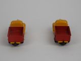 pair of red and yellow toy trucks sitting on top of a white surface