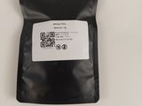 a close up of a black bag of food on a white surface