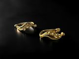 a pair of gold and pearl earrings on a black surface