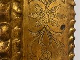 a gold vase with a decorative design on it