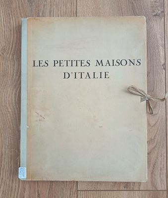 an old book sitting on top of a wooden floor next to a pair of scissors