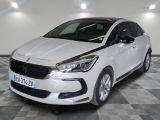 la voiture blanche est garée sur le sol à carreaux d'un garage