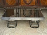a glass top coffee table with metal legs on a tile floor