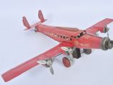 un petit avion rouge posé sur une surface blanche
