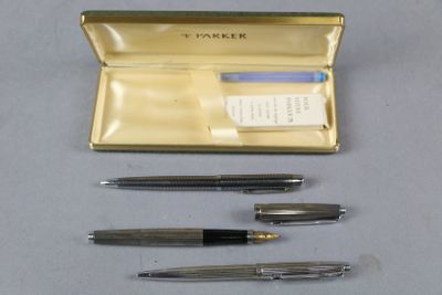 trois stylos différents et un étui à stylos posés sur une table